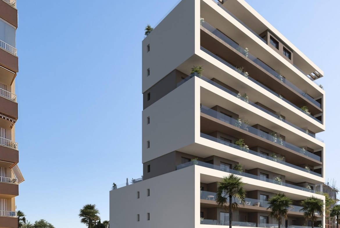 Contemporary apartment building with broad balconies and palms beside the street in Guardamar del Segura, Alicante