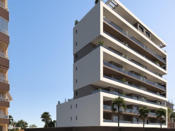 Contemporary apartment building with broad balconies and palms beside the street in Guardamar del Segura, Alicante