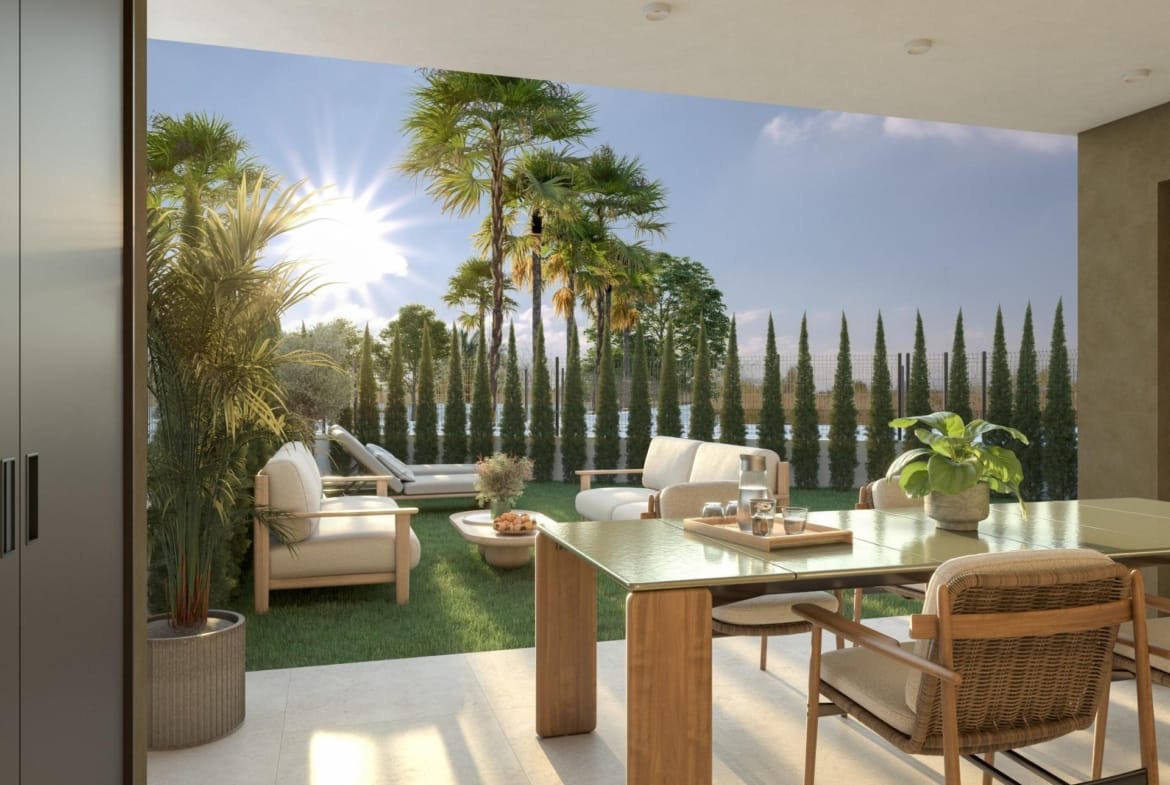 Covered dining terrace opening onto a garden with outdoor seating and palms in Guardamar del Segura, Alicante