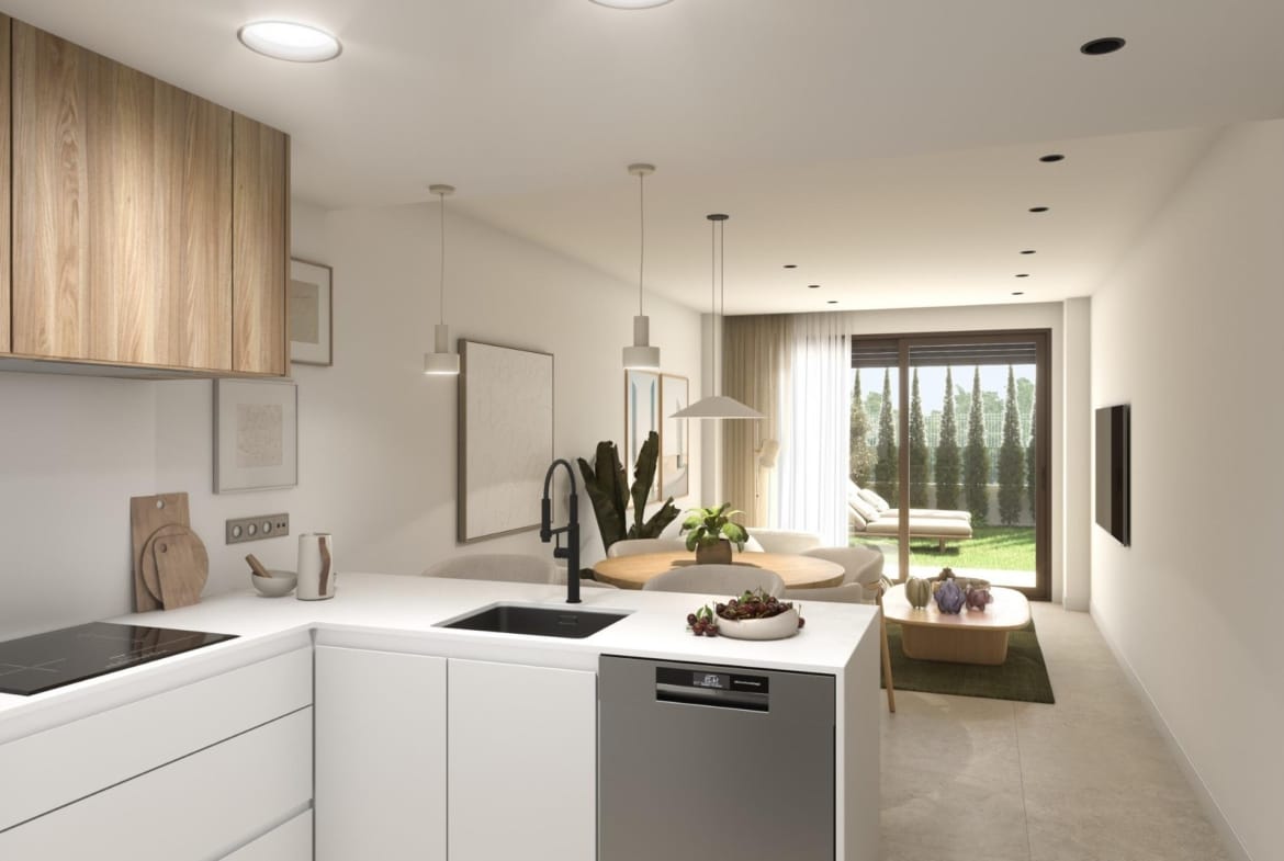 White kitchen with a black sink looking towards the dining area, living room and garden in Guardamar del Segura, Alicante