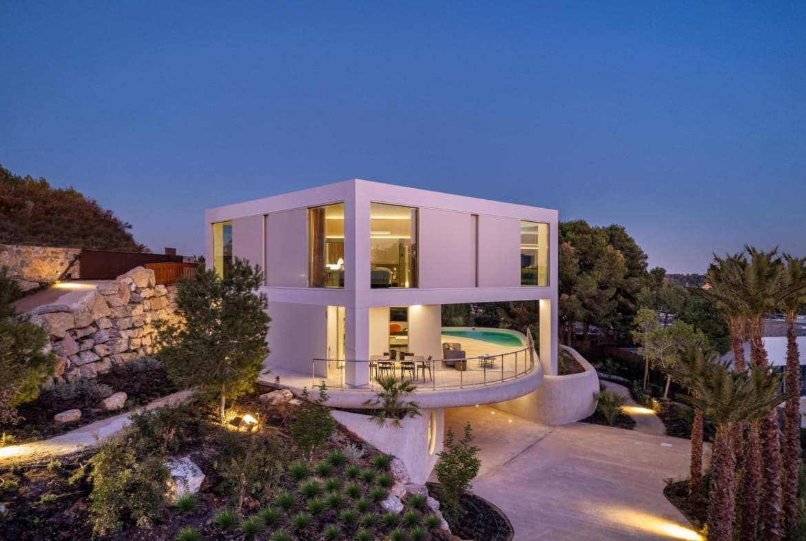 Evening exterior of a villa with landscaped garden at Las Colinas Golf, Orihuela, Alicante