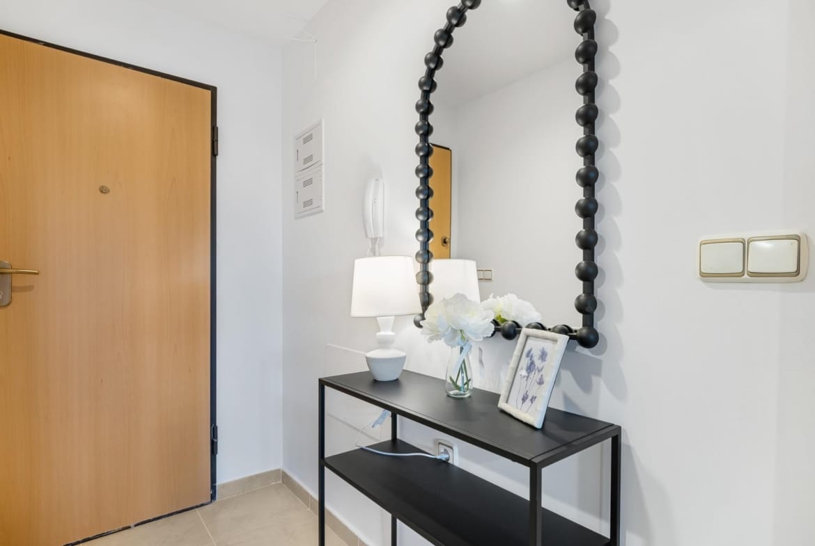 Entrance door beside a console table and mirror in Lomas de Cabo Roig, Alicante