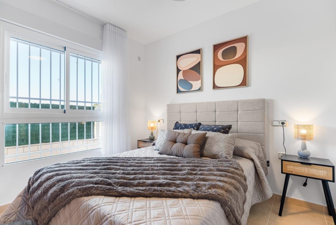 Double bedroom with window and bedside lamps in Lomas de Cabo Roig, Alicante