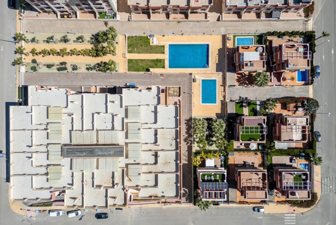 Overhead view of the apartment roofs and communal pools in Lomas de Cabo Roig, Alicante