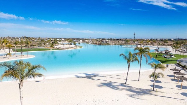 Crystal lagoon, sandy beach and palm trees at Santa Rosalía Lake and Life Resort, Torre Pacheco